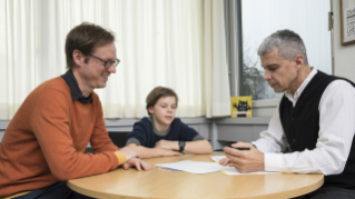Vater, Sohn und Schulpsychologe besprechen das Vorgehen